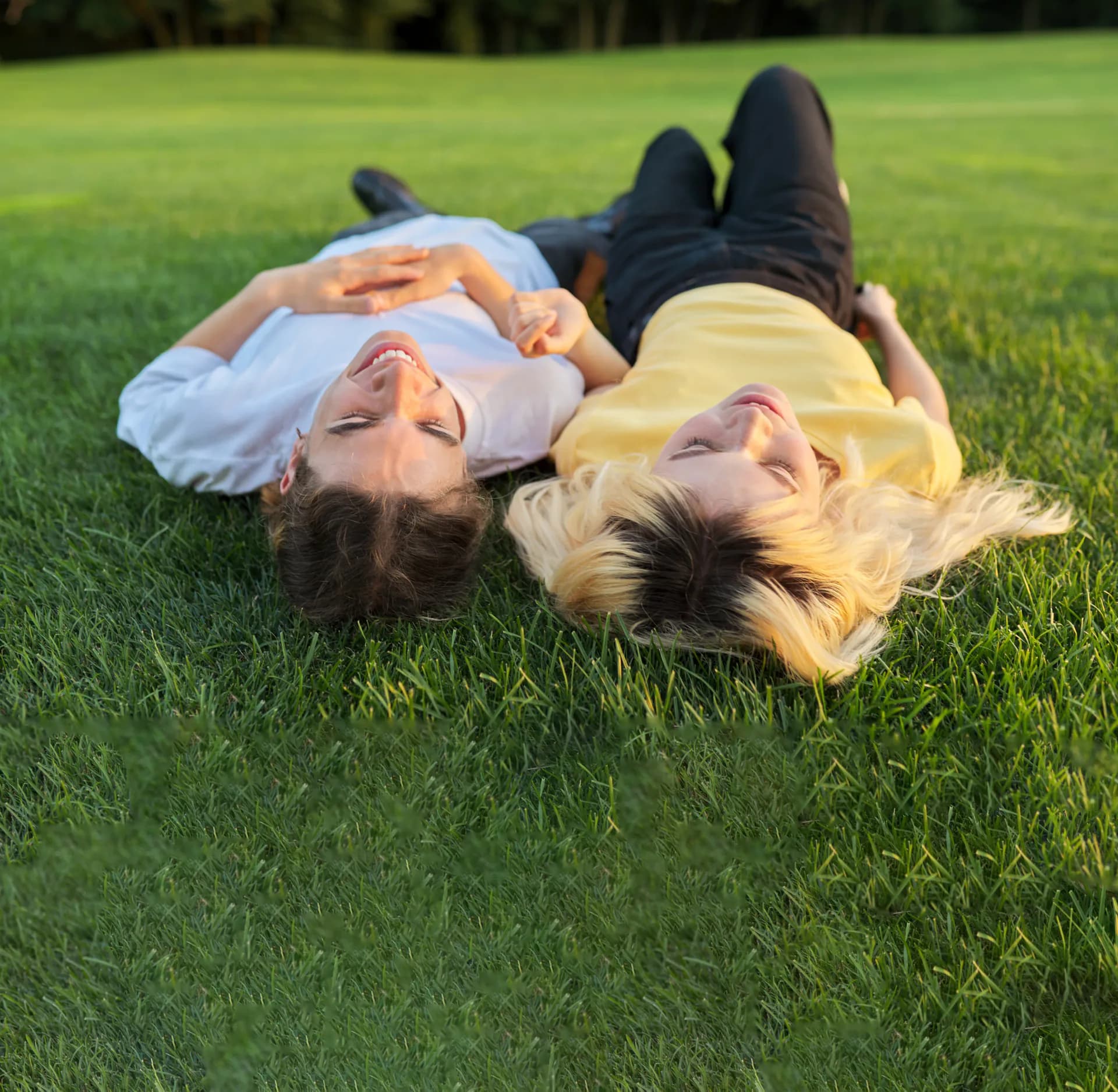 Zwei Personen liegen entspannt im Gras