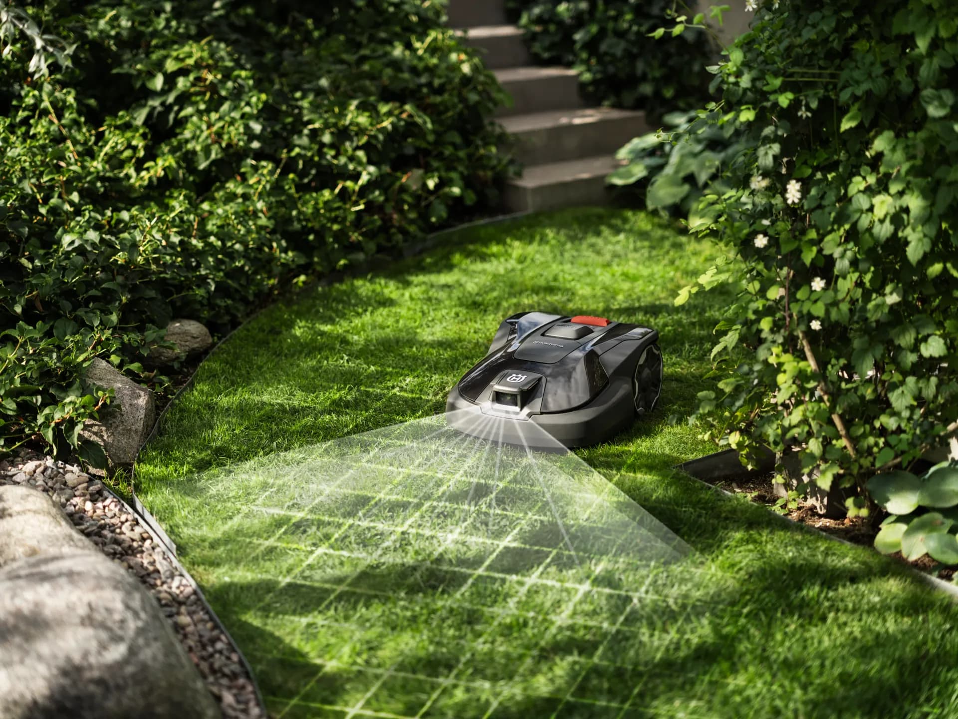 Mähroboter in einem angelegten Garten mit Treppe und Beeten