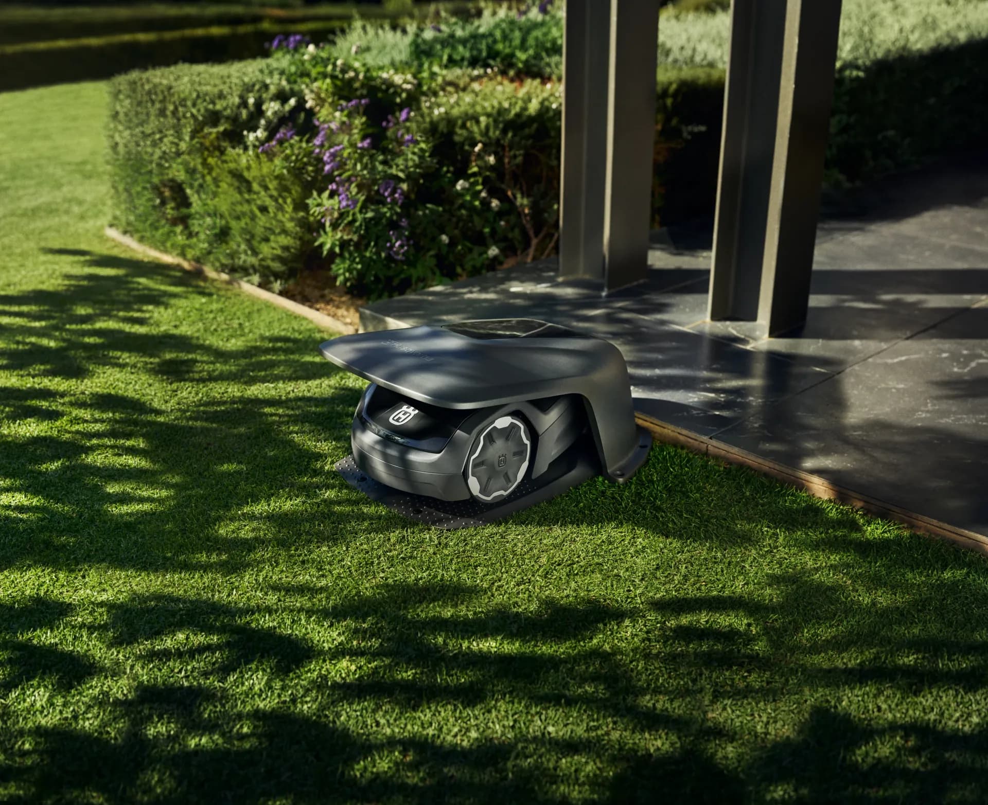 Robot de tonte au bord d'une terrasse dans un jardin privé
