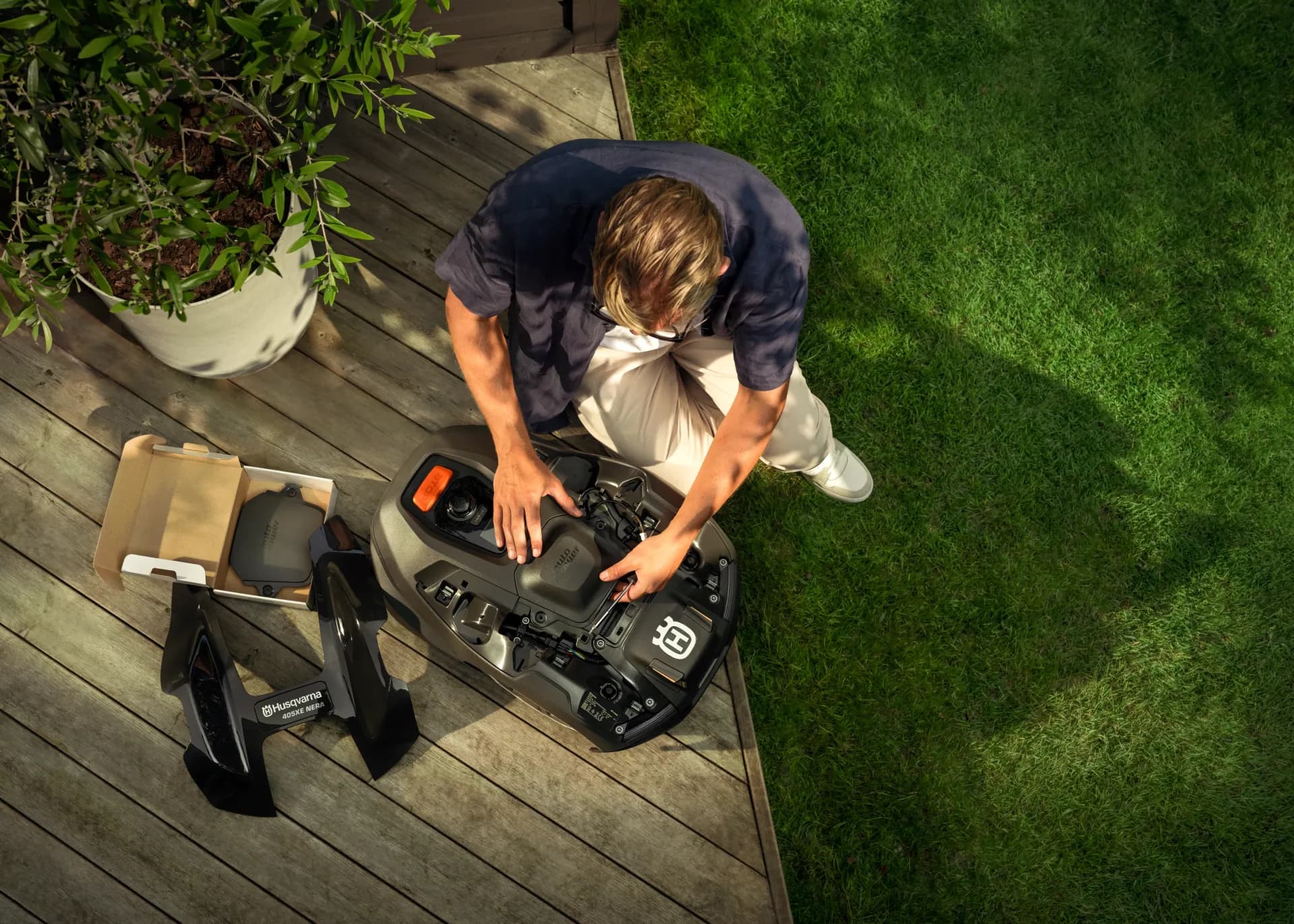 A robotic mower being unpacked and set up on a terrace