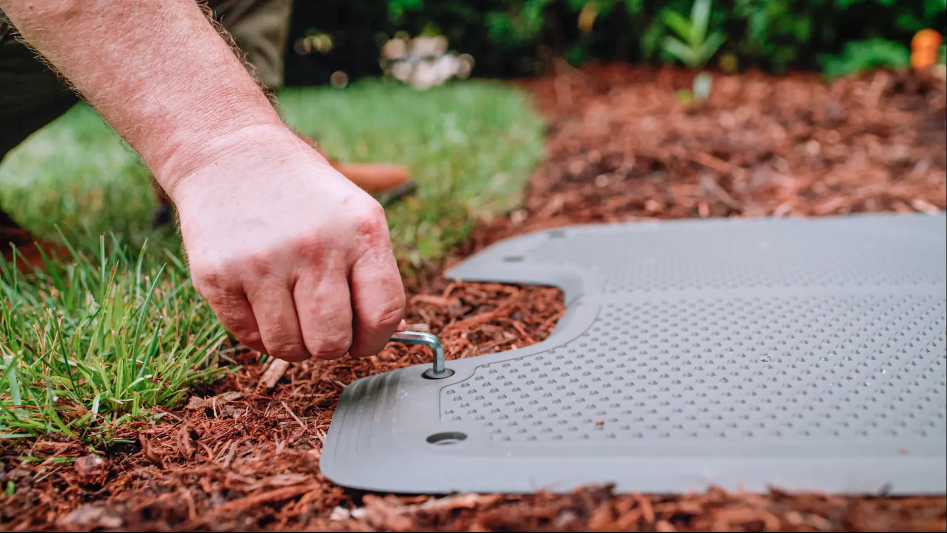 The base plate of a charging station being secured with a ground peg